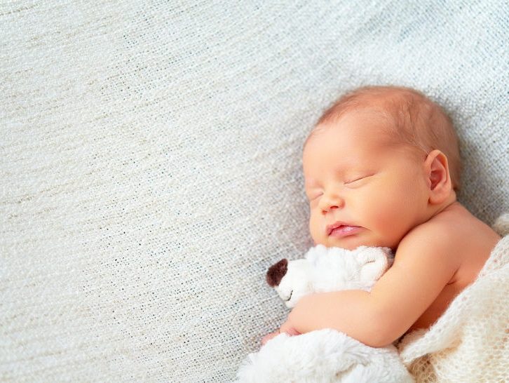 51236159 - cute newborn baby sleeps with a toy teddy bear white